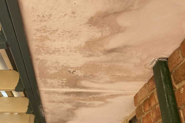 Ceiling water damage from roof overflow due to blocked downpipes